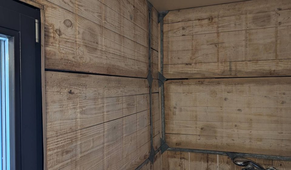 Angle de salle de bain habillé de panneaux de coffrage récupérés en bois et métal