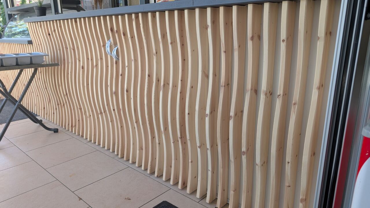 Façade de comptoir habillée avec des lames de bois verticales