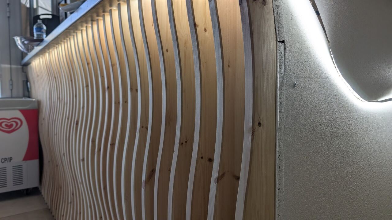 Lames de bois courbes rétroéclairées par un ruban LED