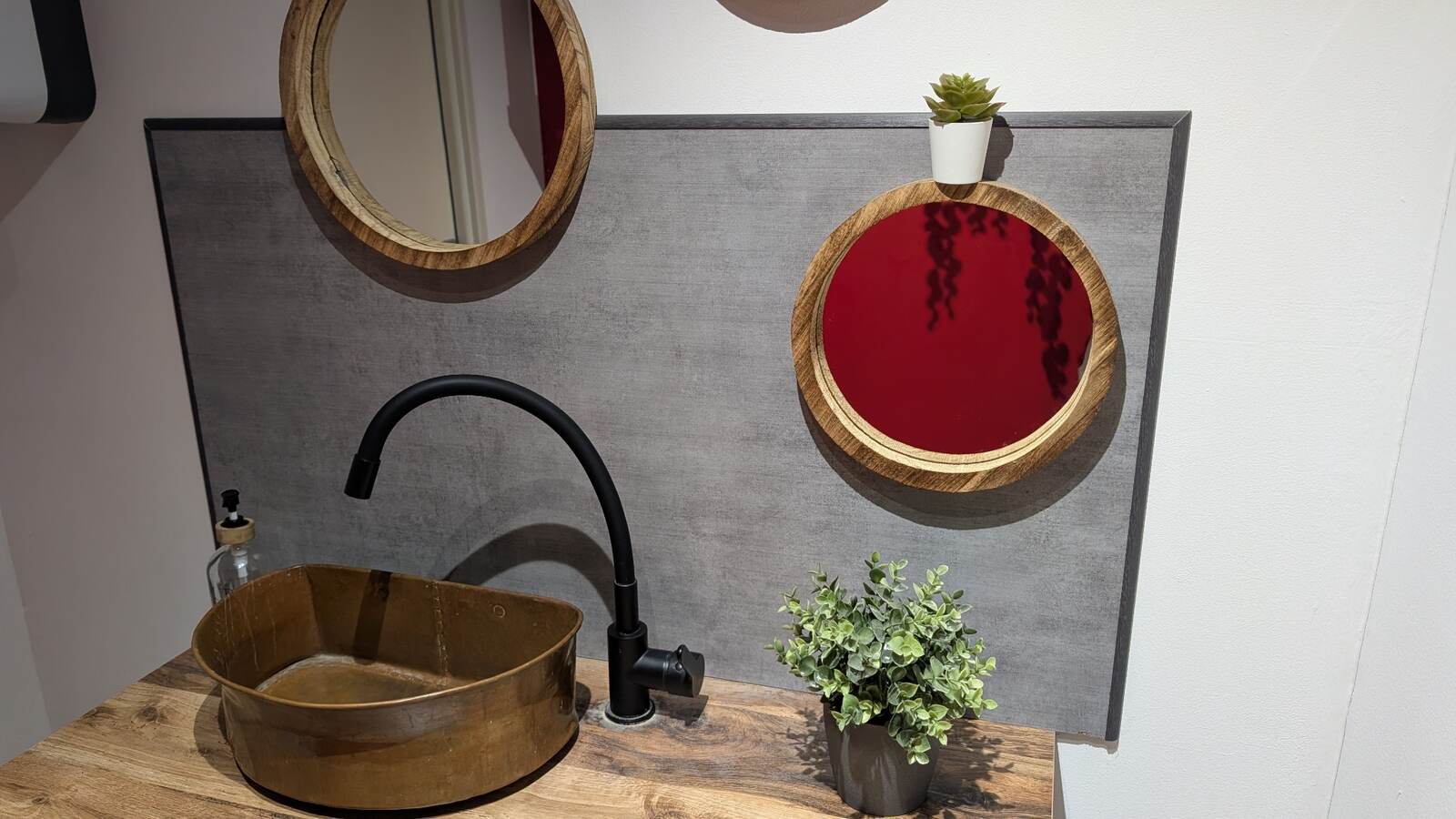 Miroirs ronds au-dessus d’un lave-mains en cuivre